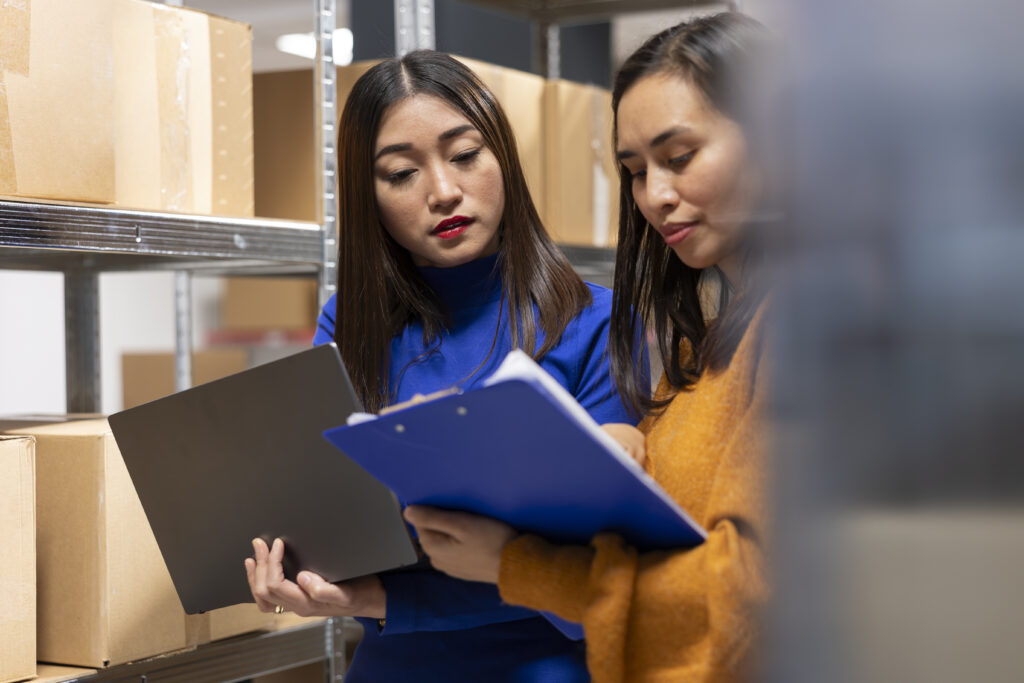 startup employees hand packing products in a warehouse shipping area