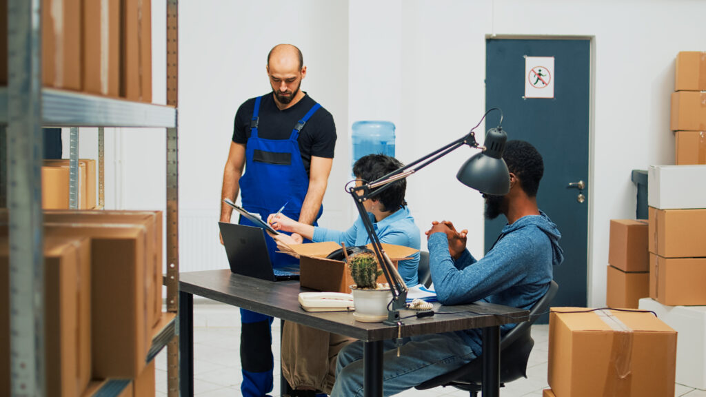 team entrepreneurs preparing merchandise order storage room woman signing delivery logistics papers startup owners using warehouse stock ship customers financial planning