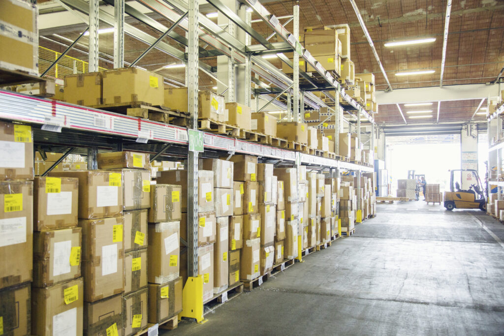 forklift trucks working in distribution warehouse aisle